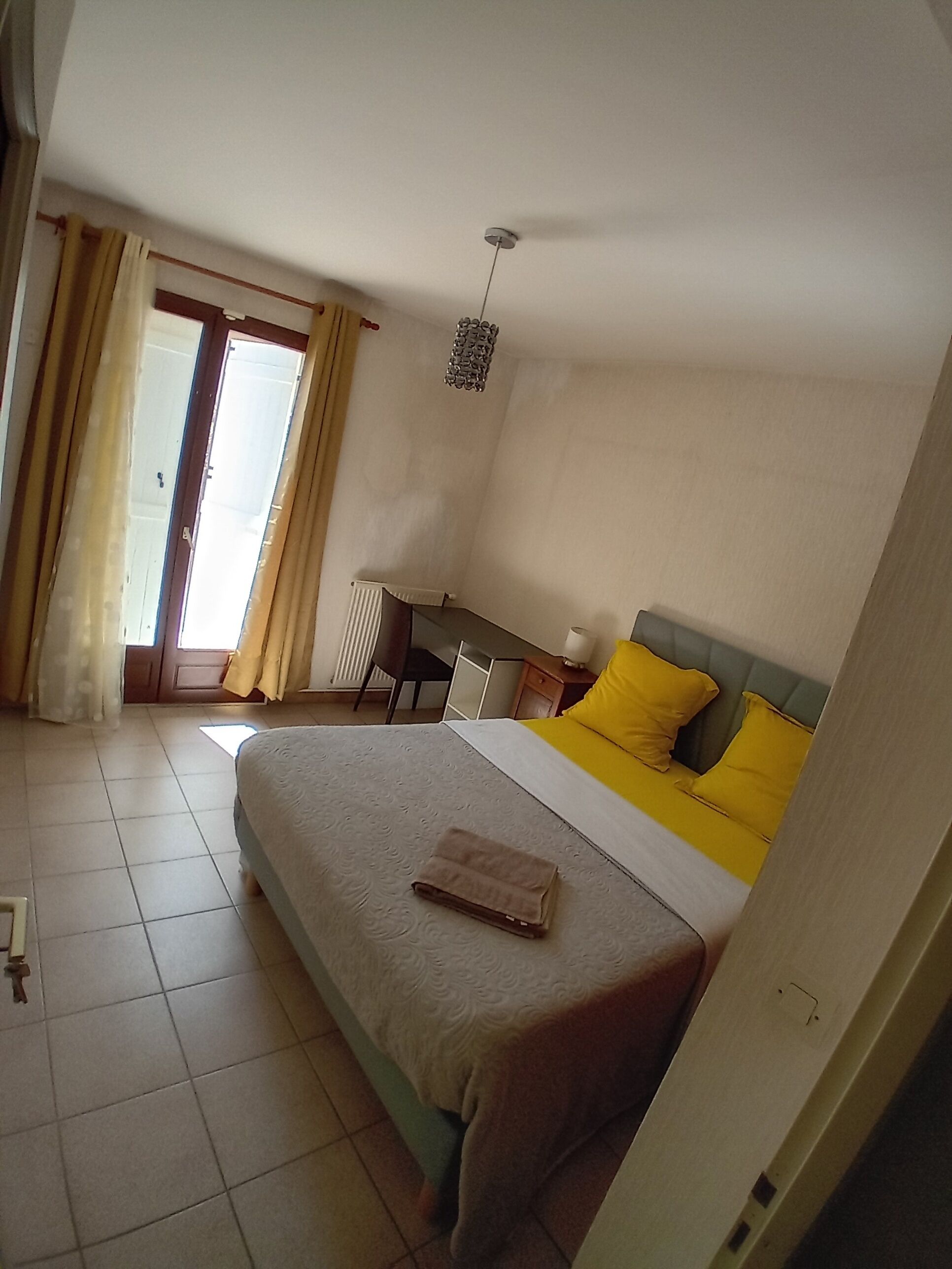 Een slaapkamer met een bed, een bureau en een stoel.