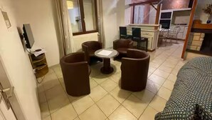 Un espacio habitable compacto con comedor, kitchenette y cama.
