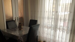 A dining area with a round table, chairs, a vase, and a patterned rug.
