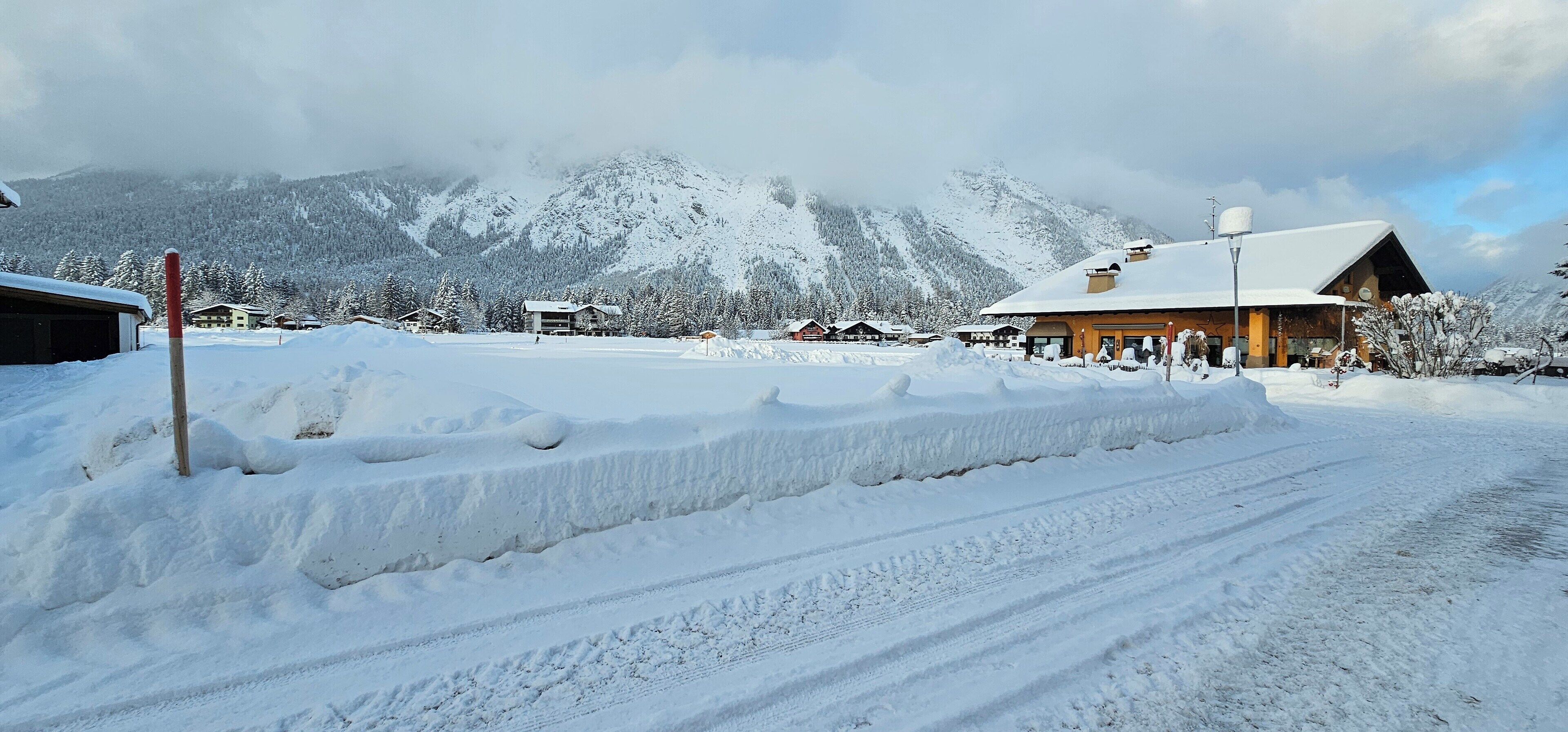 Een besneeuwd berglandschap met een lodge met een houten gevel en een sneeuwbedekte dak.