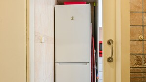 A white refrigerator with a logo, a red object on top, and a door handle. - Cozy two-bedroom apartment in Delicias (Madrid)