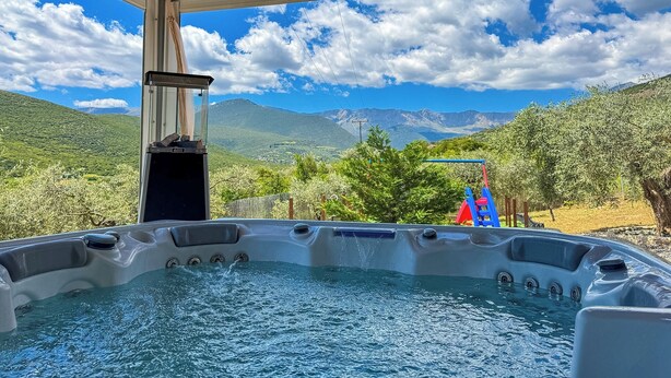 Een hottub met uitzicht op bergen en een heldere lucht.