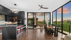 Enjoy meals at the dining table near the sliding glass door, which leads to a balcony with a scenic view.