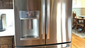 A stainless steel refrigerator with a water dispenser and a freezer compartment.