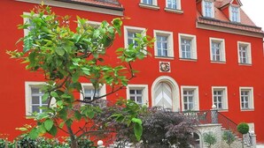 Un edificio rojo con varias ventanas y una puerta central.