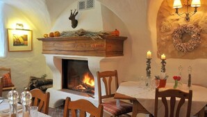 Un comedor acogedor con chimenea, muebles de madera y una mesa dispuesta para dos.