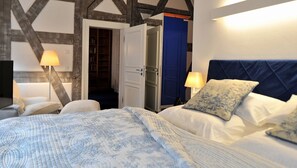 Un dormitorio con cama, lámparas de noche, un armario y una puerta que da al baño.