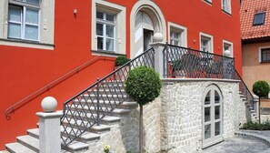 Un edificio rojo con una escalera de piedra que lleva a un balcón.
