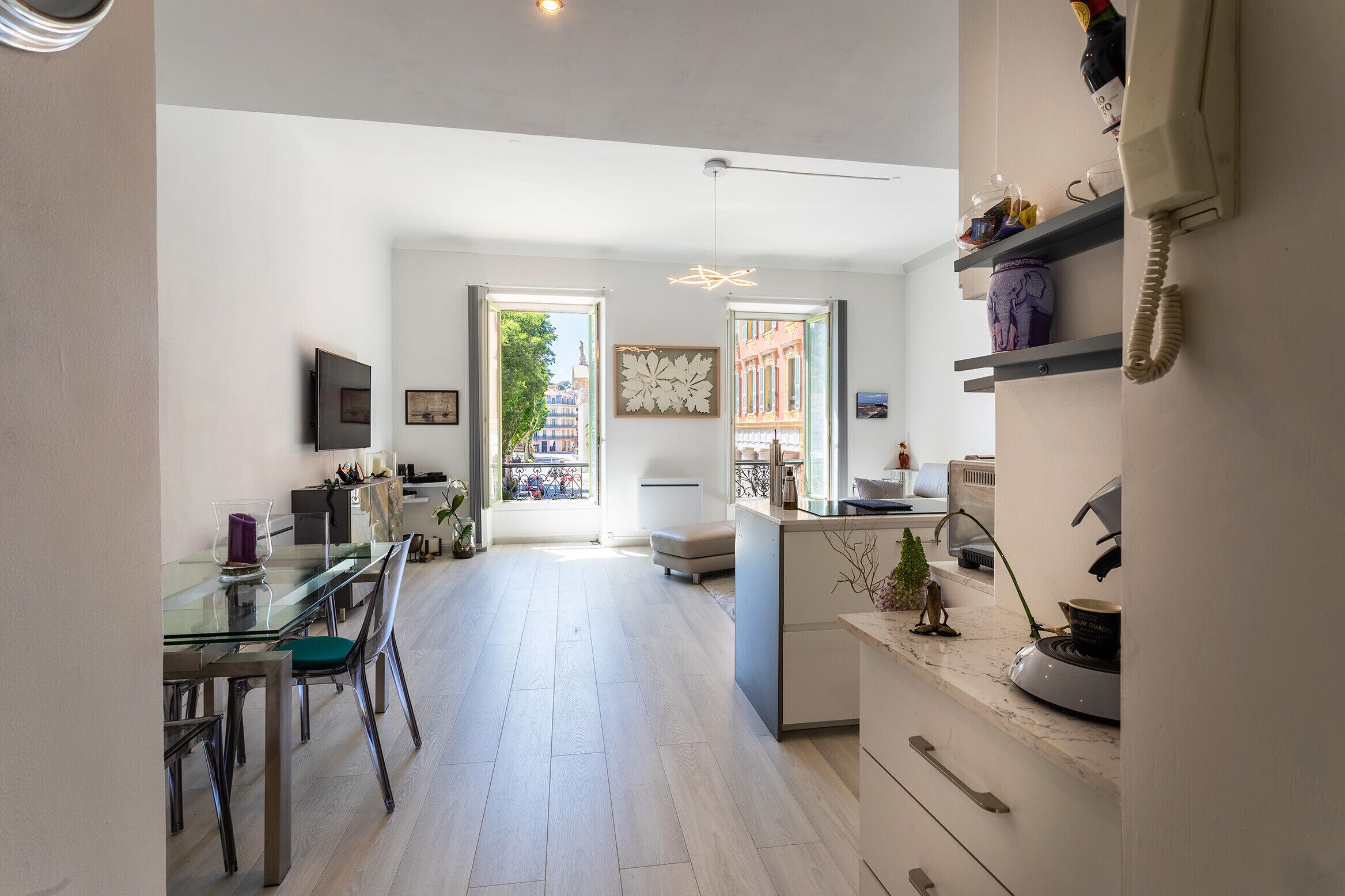 A spacious kitchen with a dining area, a large window, and a view of the cityscape.