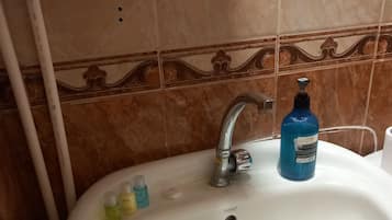 Een haardroger, handdoeken, zeep, toiletpapier