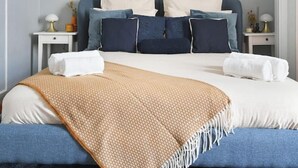 A bedroom with a bed, bedside tables, a wall-mounted mirror, and a decorative sunburst light fixture. - Top Location 4P Studio - Champs-Elysées Best Stay (Paris)