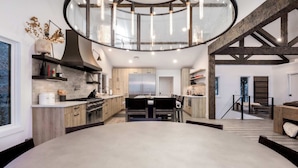 Una cocina moderna con una isla central, armarios de madera y una lámpara colgante.