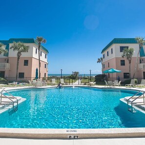 Relax by the hotel's central pool surrounded by lounge chairs and umbrellas.