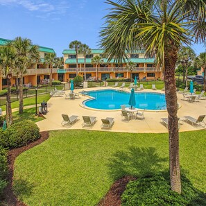 Relax by the resort's central pool surrounded by lounge chairs and umbrellas.