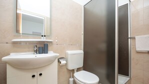 Ein modernes Badezimmer mit Waschbecken, Toilette und Dusche.