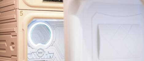 Ein weißes Gerät mit rundem Fenster und Bedienfeld, Nummer 5, auf einer Küchenarbeitsplatte.