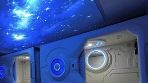 Una habitación con techo estrellado, lámparas circulares y diseño moderno.
