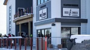 Ein modernes Gebäude mit einem Schild für die Bar „High Timber Lounge“ an der Fassade.