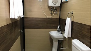 Une salle de bain équipée d’un lavabo, de toilettes et d’un porte-serviettes.