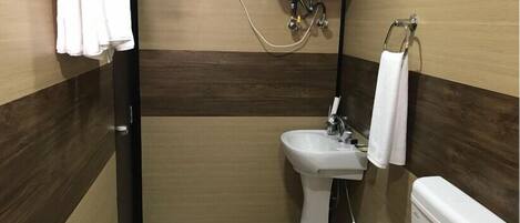 Un baño con lavamanos, inodoro y toallero.