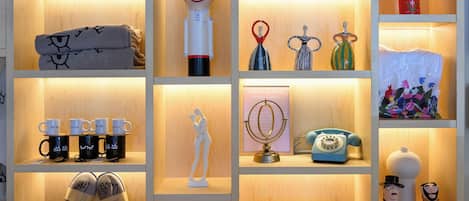 A wooden display cabinet with various decorative items including figurines, mugs, and a vintage telephone.