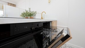 Una cocina moderna con lavavajillas, un fregadero y una planta en maceta sobre la encimera.
