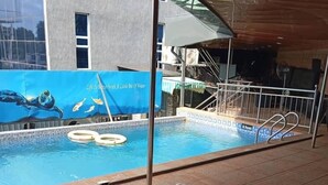 Ein Poolbereich mit Liegestühlen und einem Wandgemälde mit Meereslebewesen.