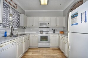 Fridge, microwave, oven, stovetop - 1212 The Havens - Barefoot Resort Rentals (North Myrtle Beach)