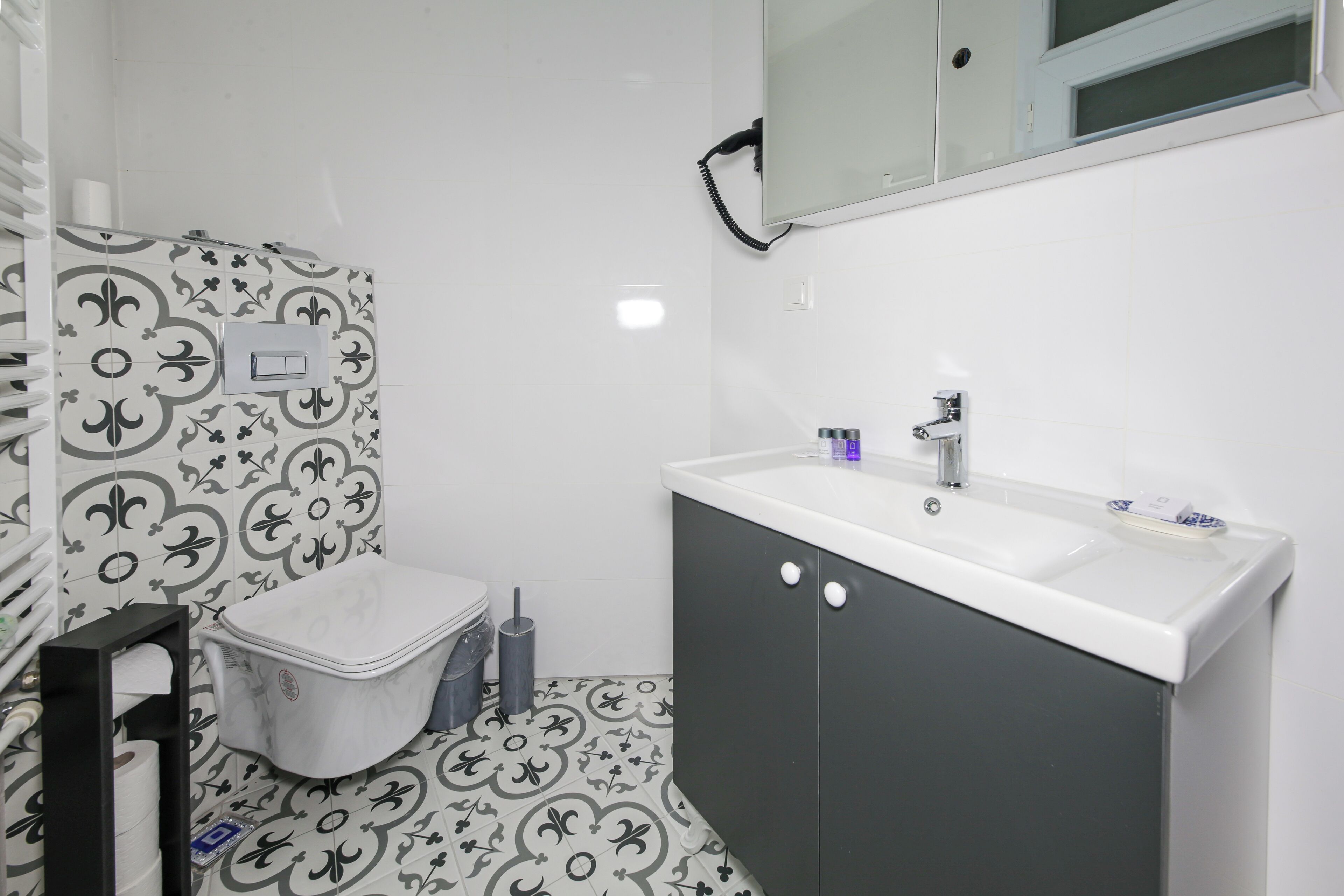 Un baño con inodoro, lavamanos y espejo.