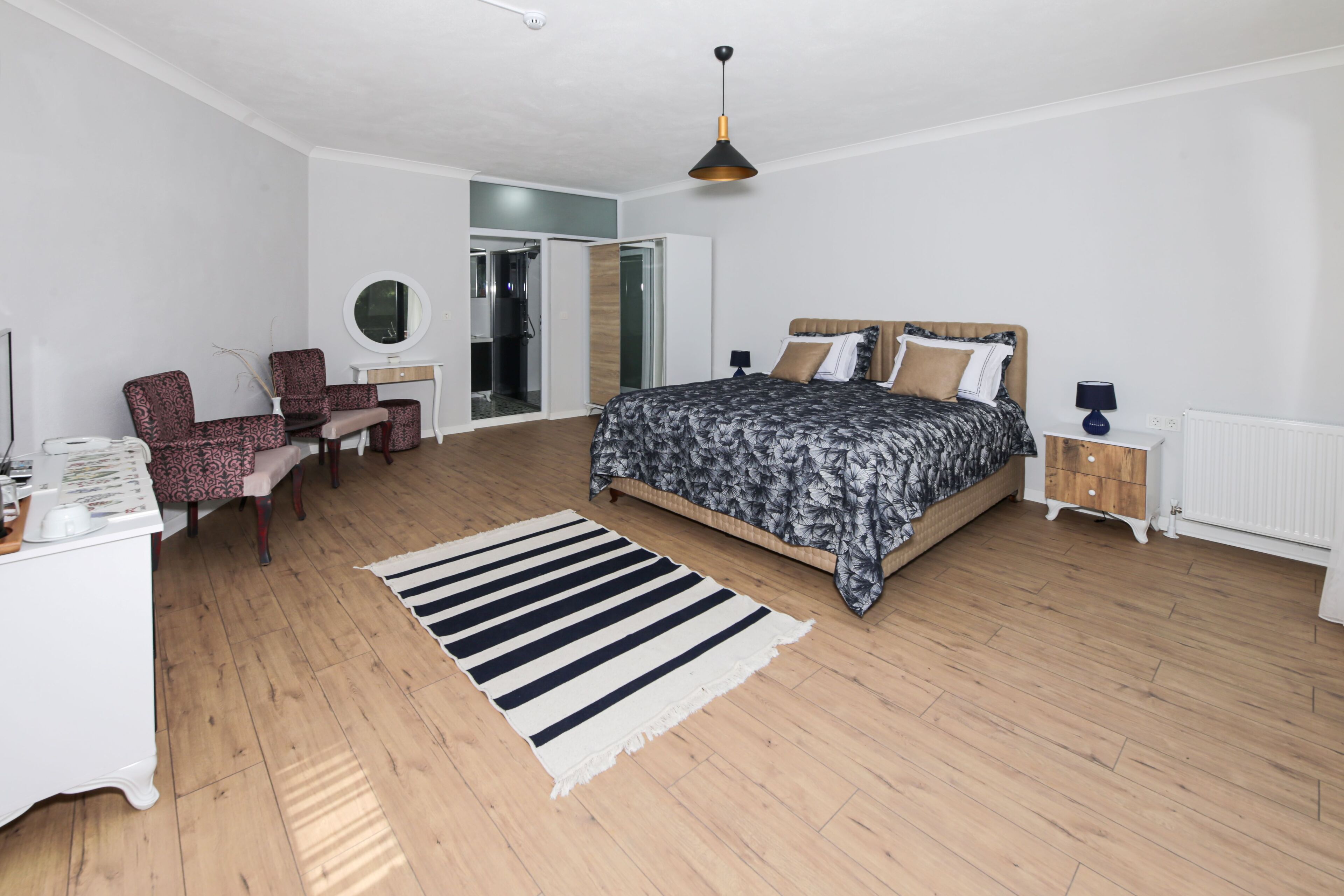 Ein Schlafzimmer mit einem Bett, einem Schreibtisch, einem Stuhl und einem Kleiderschrank.