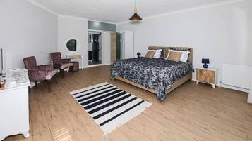 Ein Schlafzimmer mit einem Bett, einem Schreibtisch, einem Stuhl und einem Kleiderschrank.