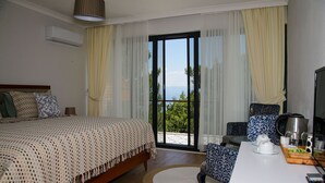 Une chambre d’hôtel avec un lit, une table à manger avec des chaises, une machine à café et une vue sur l’extérieur.