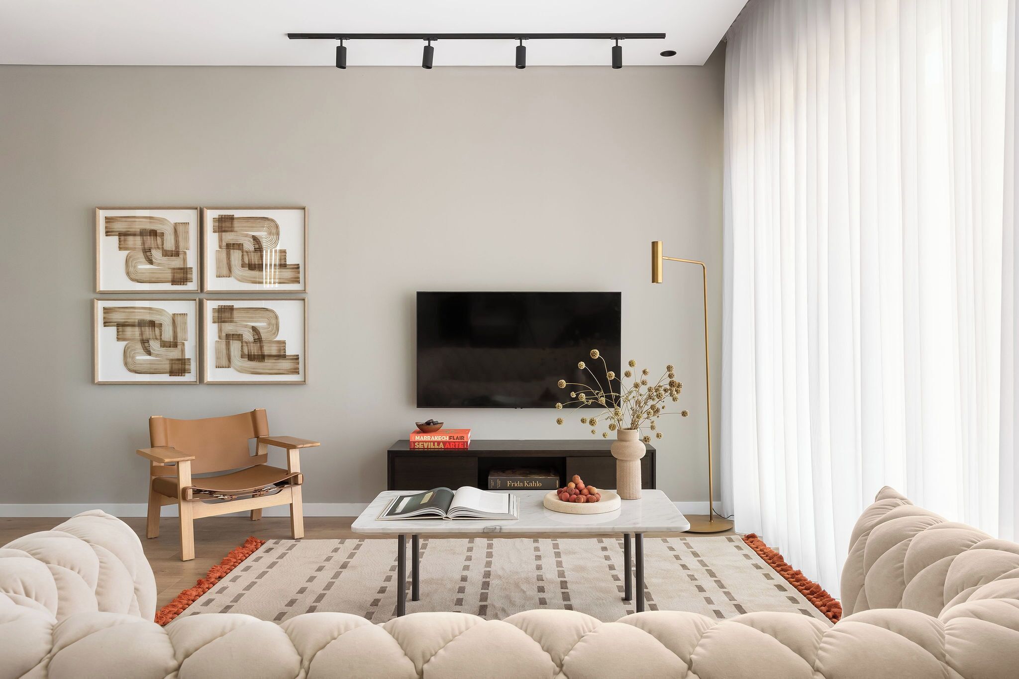 Una sala de estar moderna con una televisión de pantalla plana, un sofá, una mesa de centro y una silla.