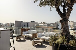 Una piscina al aire libre, sombrillas, sillones reclinables de piscina