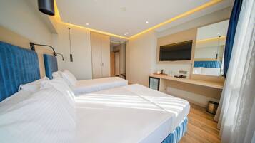 Une chambre d’hôtel moderne, dotée d’un grand lit, de tables de chevet, d’une télévision et d’une salle de bain.