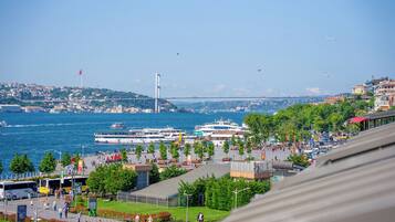 Une promenade en bord de mer, avec un pont en arrière-plan, des bateaux et une vue sur le paysage urbain.