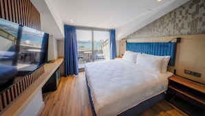 A modern hotel room with a large bed, a TV, and a view of the city. - The Palm Bosphorus Hotel (Istanbul)