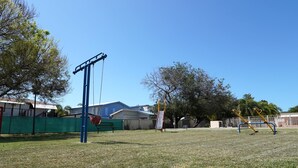 Un'area giochi all'aperto con altalene e una struttura per arrampicata.