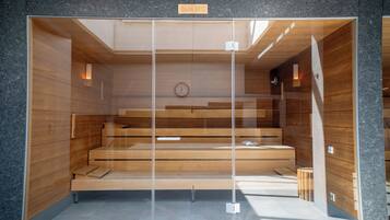 A sauna with a wooden interior, a clock, and a sign indicating 90°C temperature.