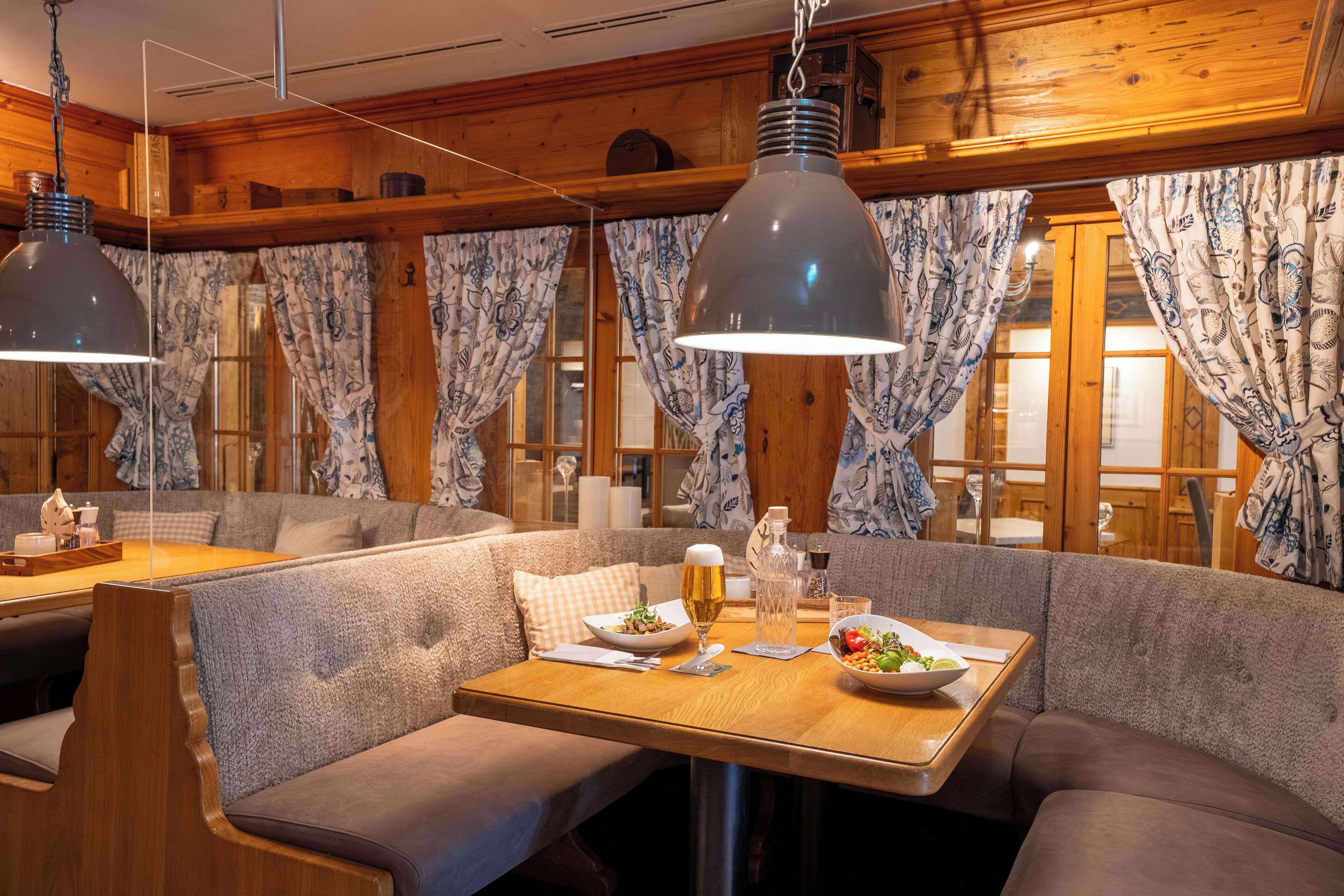 A cozy restaurant with wooden walls, a wooden table, and a bench seating area.