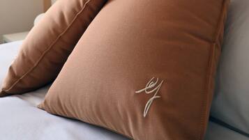 Una cama con dos almohadas marrones y un cabecero blanco.