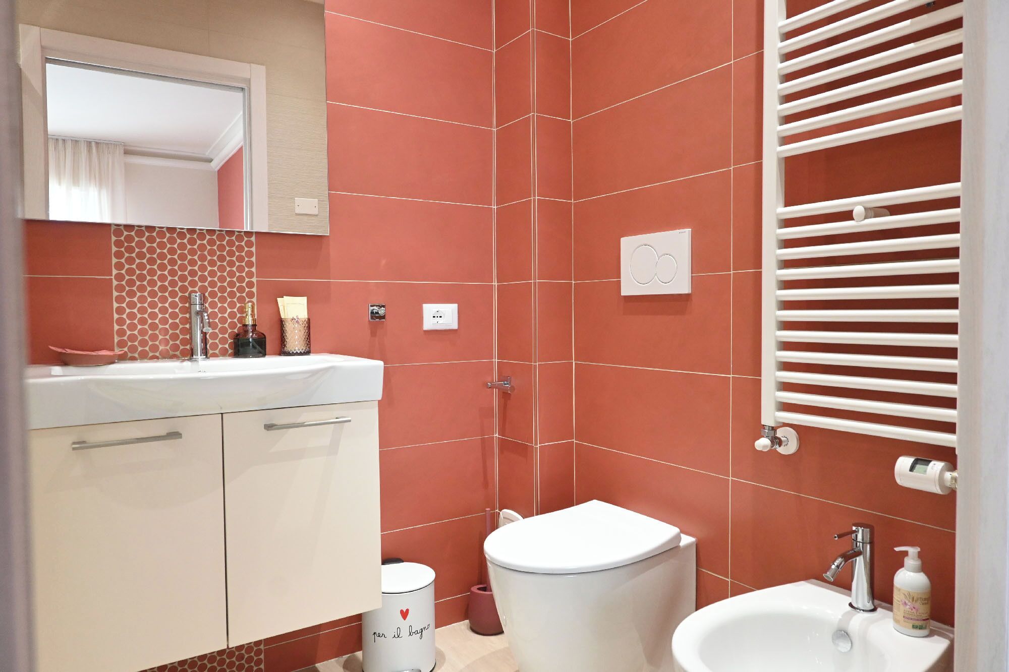 A bathroom with a white sink, a toilet, and a shower area.