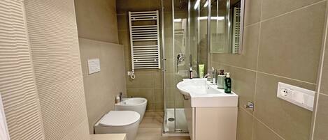 Un baño moderno con inodoro, bidé y zona de ducha.