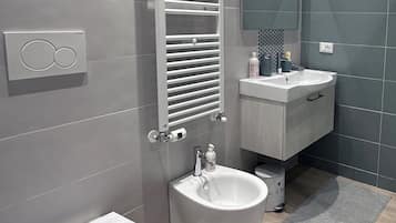 Habitación cuádruple Deluxe, balcón | Regadera, regadera tipo lluvia, secadora de cabello, bidet