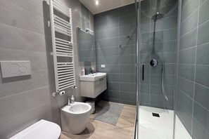 Deluxe vierpersoonskamer, balkon | Badkamer | Een douche, een regendouche, een haardroger, een bidet