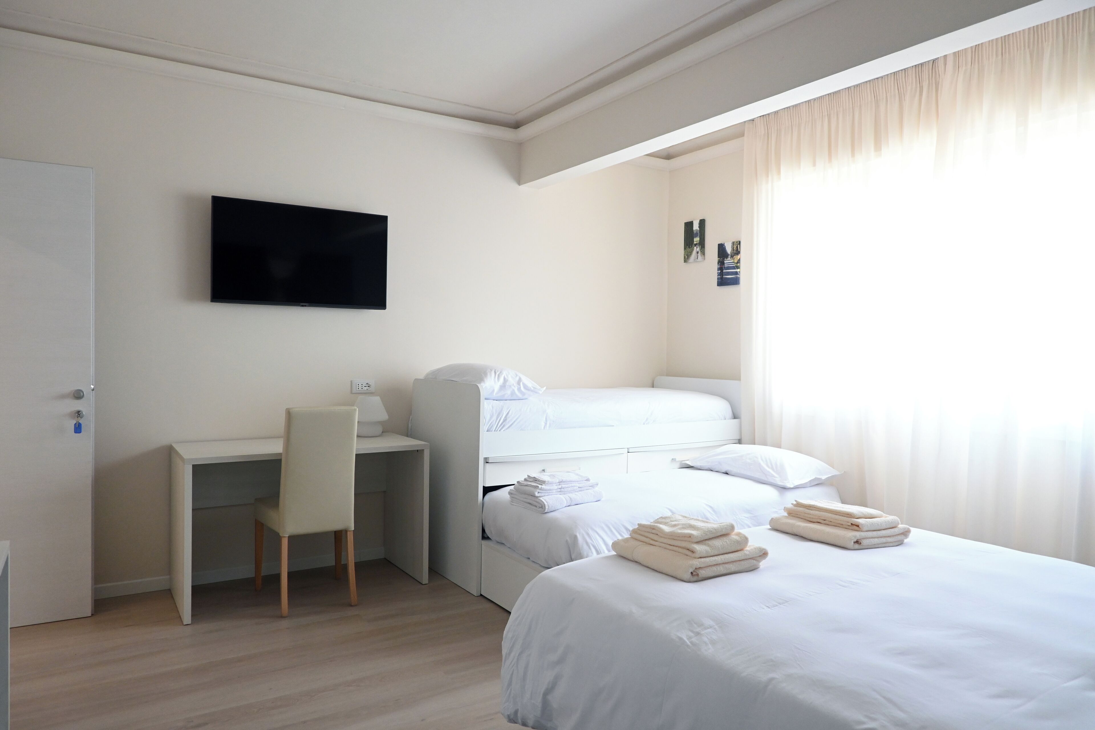 Ein Hotelzimmer mit Bett, Schreibtisch und Fernseher.
