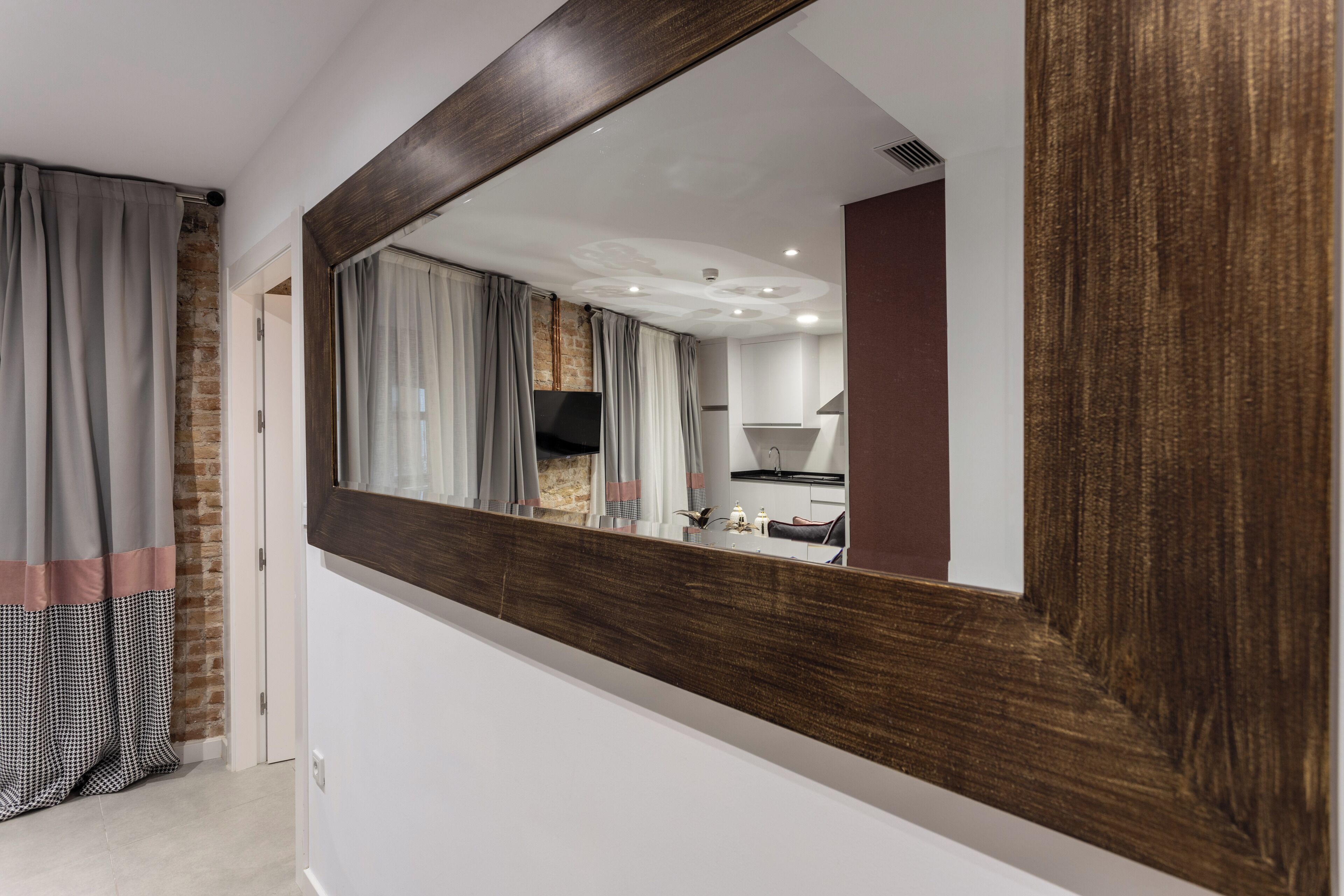 Une salle de bain avec un grand miroir, un espace douche et un lavabo.