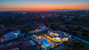 Vista aérea de un barrio residencial con casas, una piscina y un amplio espacio abierto.