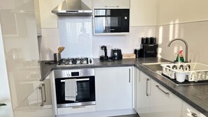 Eine moderne Küche mit Edelstahlgeräten, einer integrierten Mikrowelle und einer Kaffeemaschine.