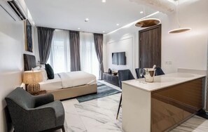 Ein modernes Hotelzimmer mit Bett, Schreibtisch, Fernseher und Bad.